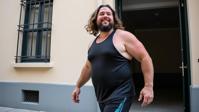 documentary photography of a hefty man as a dancer with wavy hair Wearing sportswear,functional with athletic shoes ,dressed in black halter top,glossy texture