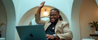 a slightly overweight middle aged man as a barber with box braids Engaged with a laptop,reflecting a tech savvy nature ,dressed in black rimmed glasses,beige blazer