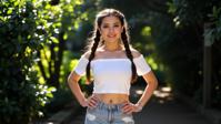 fashion photography,of a woman as a dragon tamer with pigtails Intense solo performance with a powerful voice ,dressed in white crop top,light blue ripped jeans