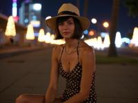 fashion photography,of a woman as a cultist recruiter with wedge cut haircut Intense solo performance with a powerful voice ,dressed in brown polka dot swimsuit,wide brimmed straw hat