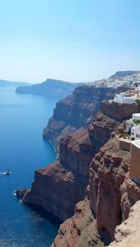 gamboge theme, The iconic cliffs of Santorini, showcasing layers of volcanic rock, topped with traditional Cycladic architecture