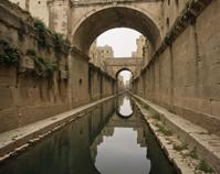 Photograph of an Unappealing Matera and Black mirror inside a Aqueduct, smoky conditions, intentional camera movement, depth of field